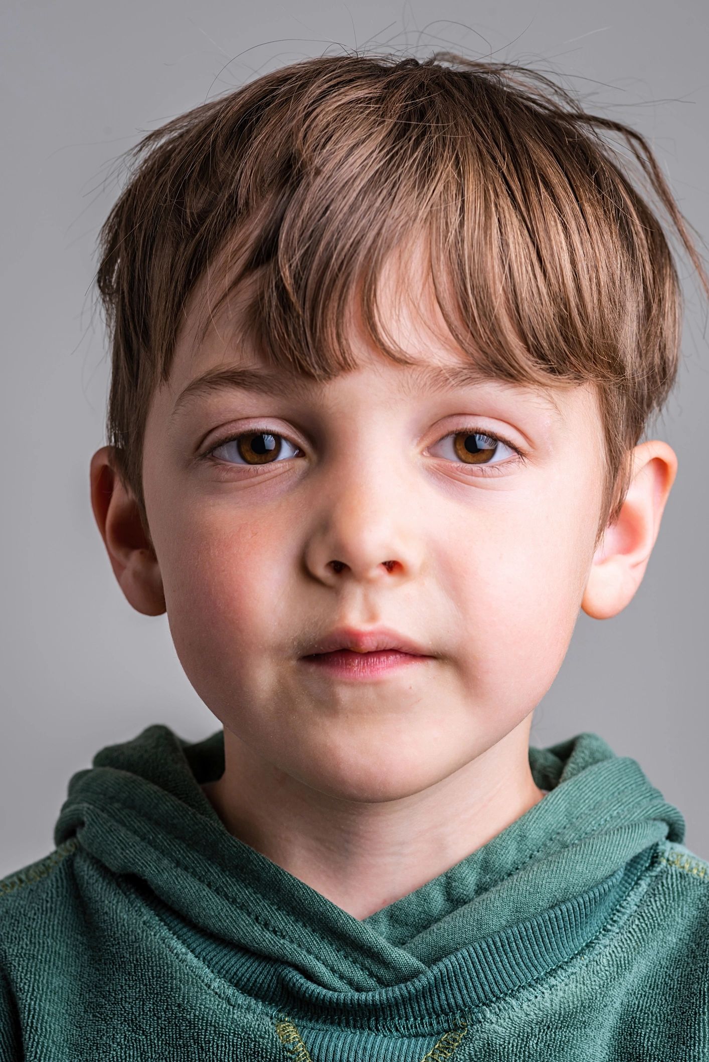 Child wearing a hoodie looking at the camera