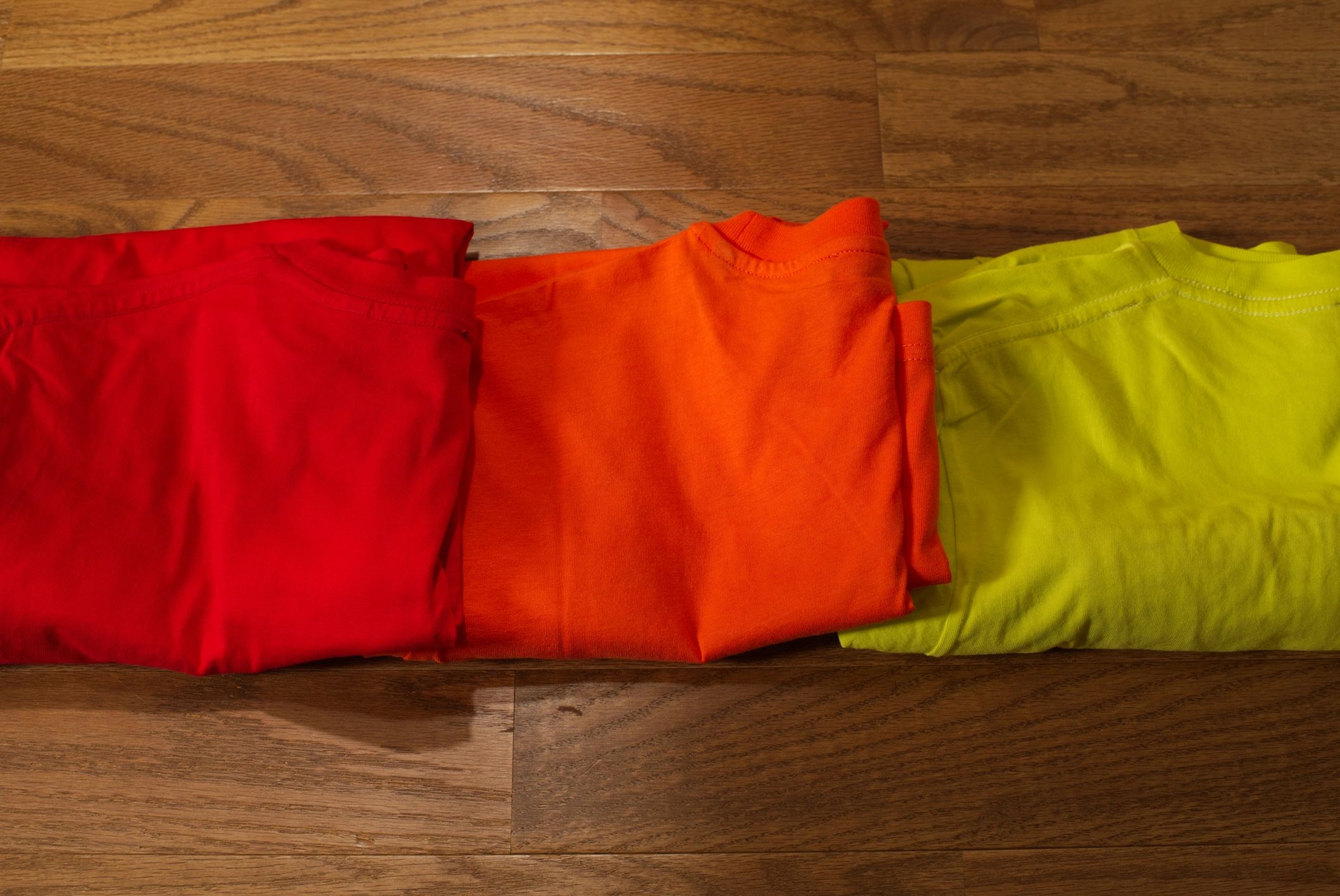 Folded colorful t-shirts laid out neatly