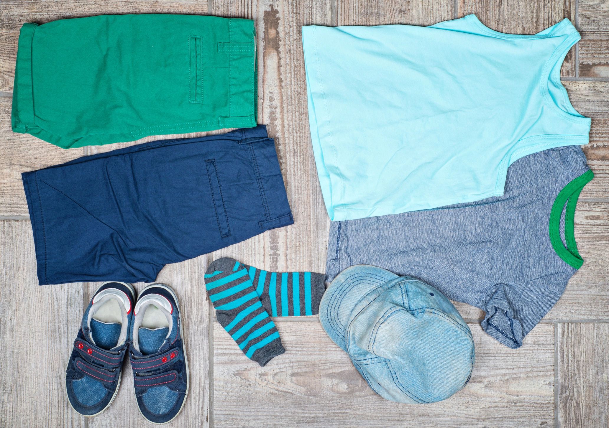 Kids clothing and shoes arranged in a flat lay